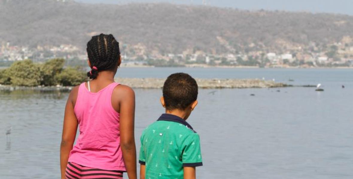 Dos niños observan la silenciosa quietud de la Ciénaga de la Virgen.